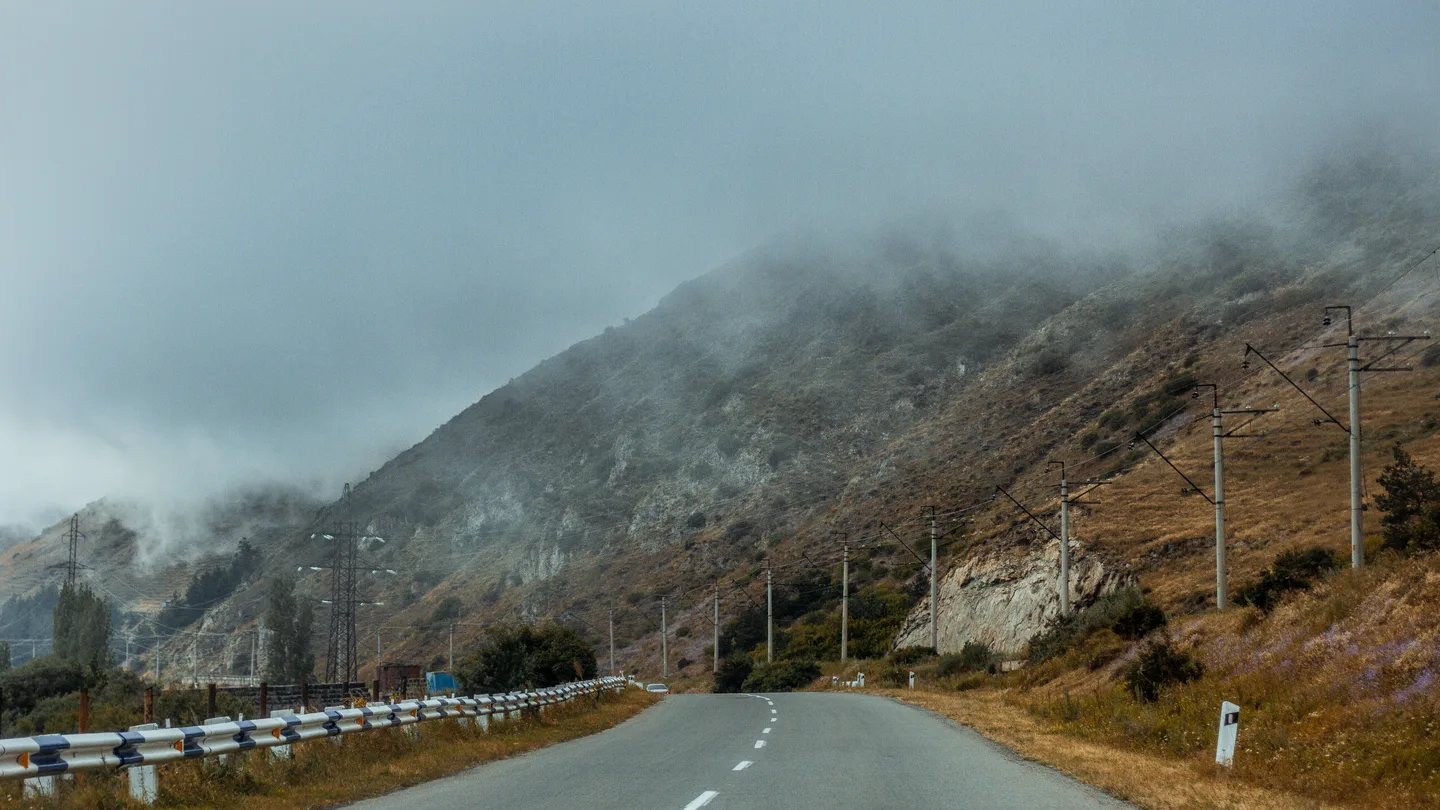Mountain road with fog illustrating weather and road safety planning