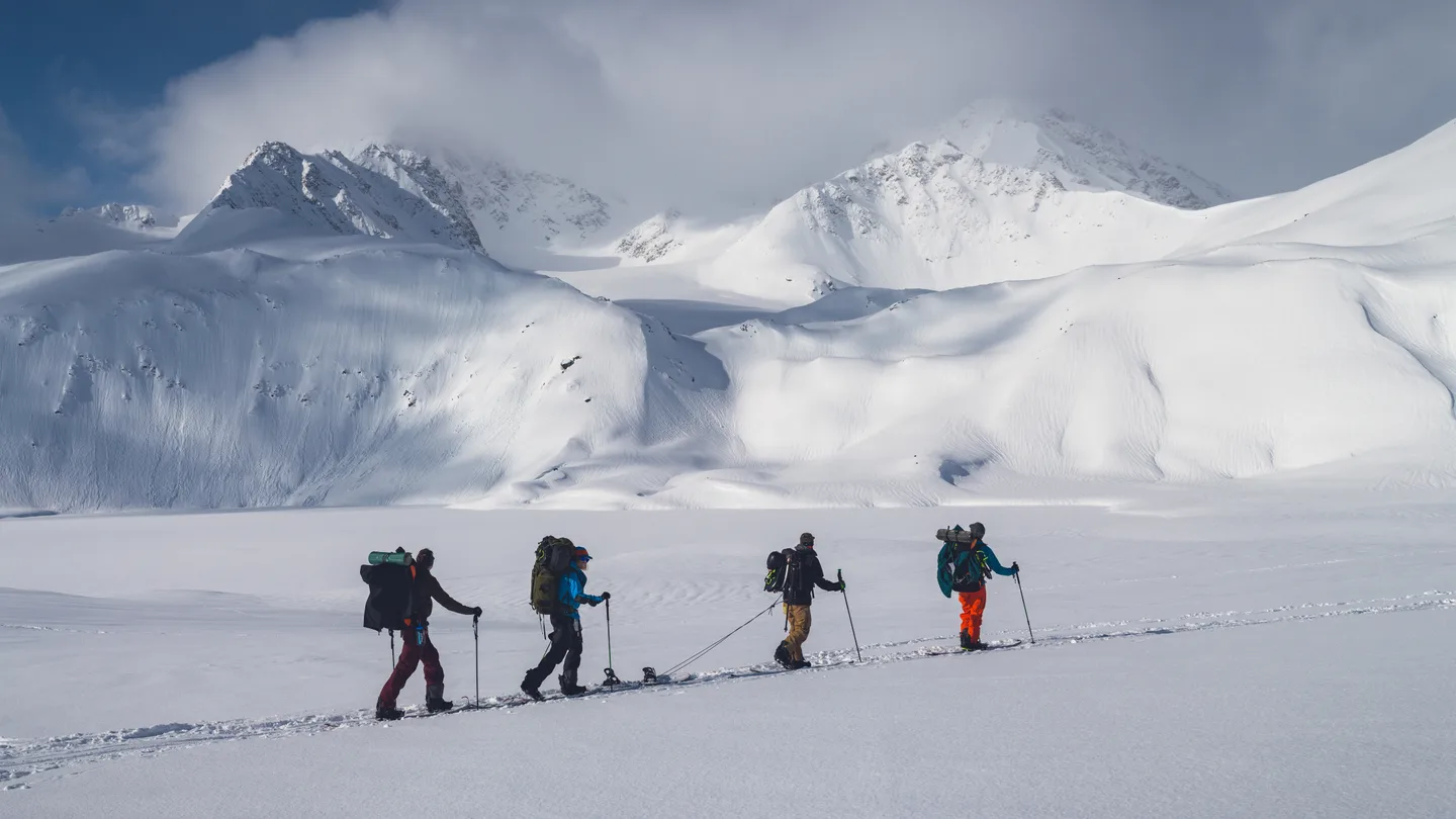 Guided hikers in snowy mountain terrain for restricted area trekking